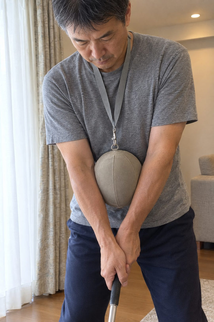 両前腕で同調スイングボールを左右から挟み、そのままグリップを握った手元